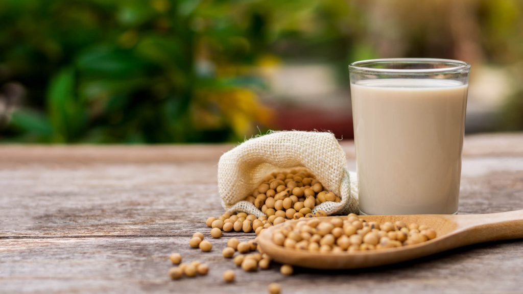 whole soy beans and a glass of soy milk